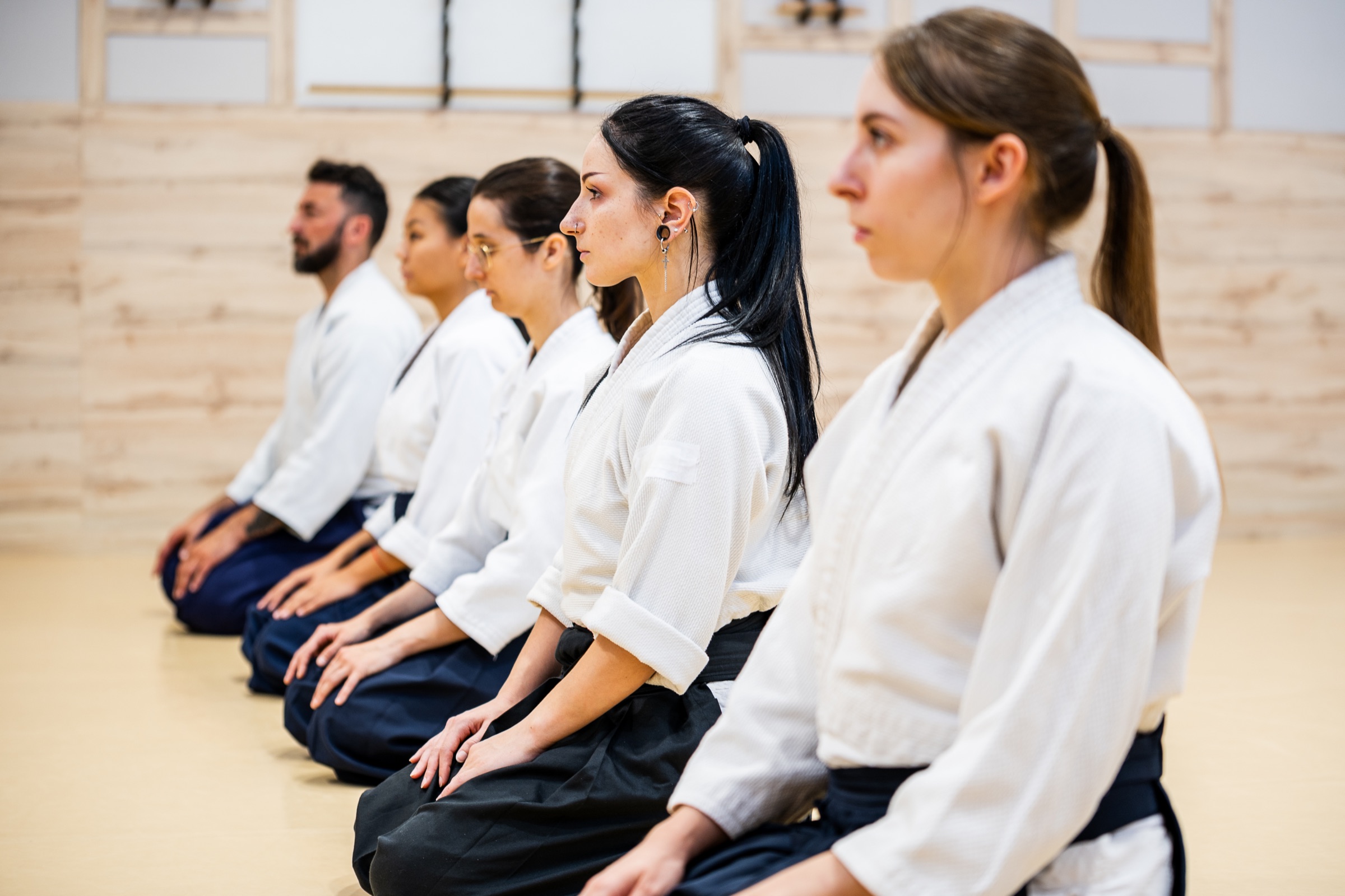 A row of aikidoka seated in seiza before the class begins.