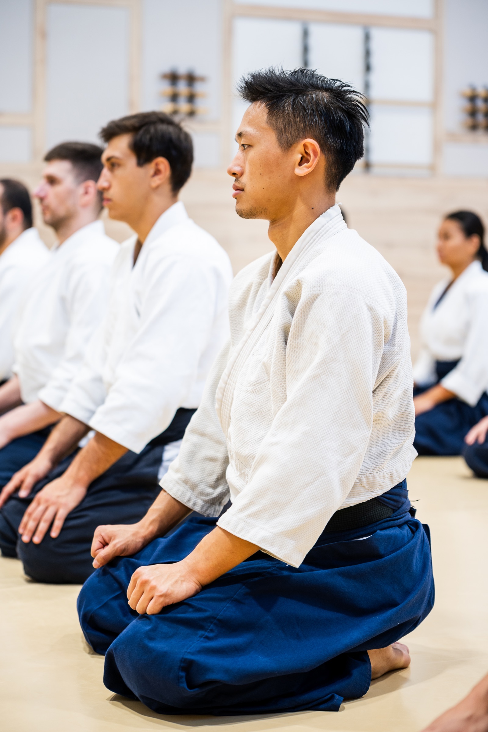 An aikidoka in seiza in the class line.